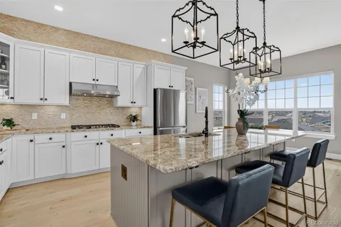 a kitchen with stainless steel appliances granite countertop a kitchen island a stove and a cabinets