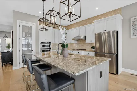 a kitchen with stainless steel appliances granite countertop a sink a stove and a refrigerator