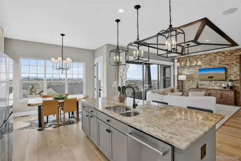 a view of a dining room and livingroom with furniture wooden floor a chandelier