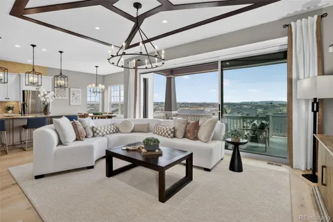 a living room with furniture ceiling fan and a large window