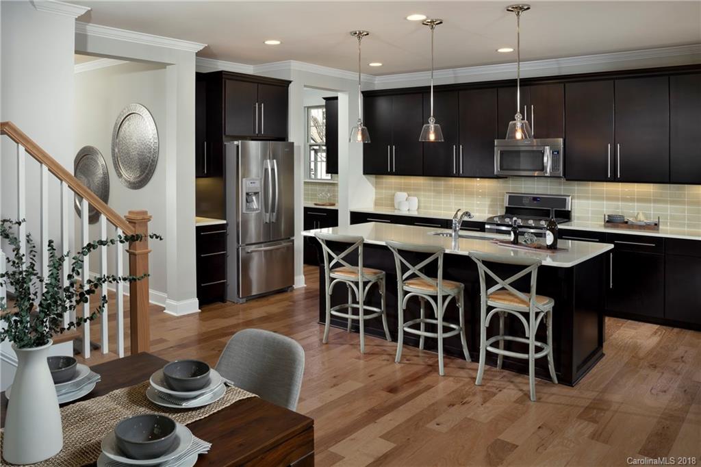 237 Helton Lane, Unit 89 Fort Mill, SC 29708 - Photo 8 of 19 a kitchen with stainless steel appliances granite countertop a stove and a dining table with wooden floor