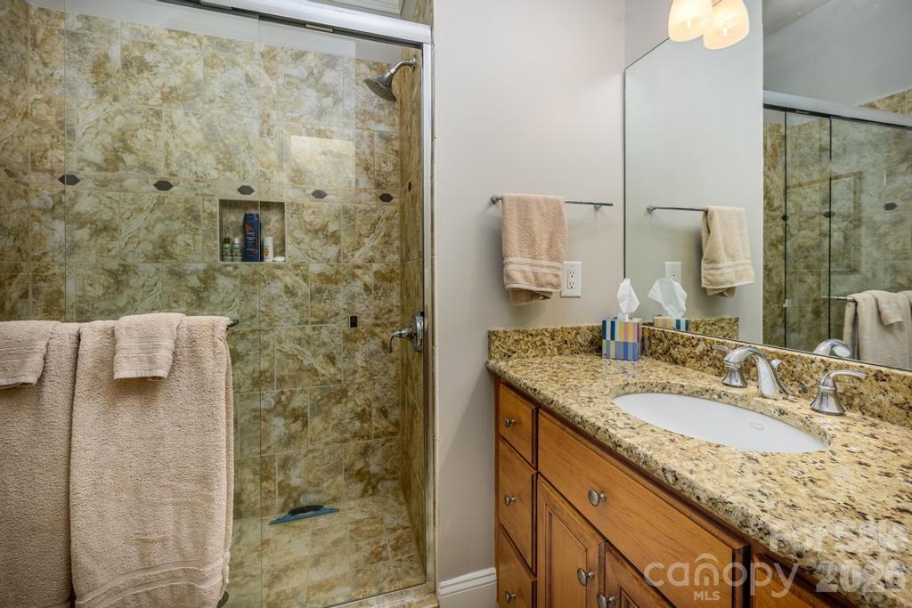7315 Bay Ridge Drive Denver, NC 28037 - Photo 38 of 39 a bathroom with a granite countertop sink a mirror and shower