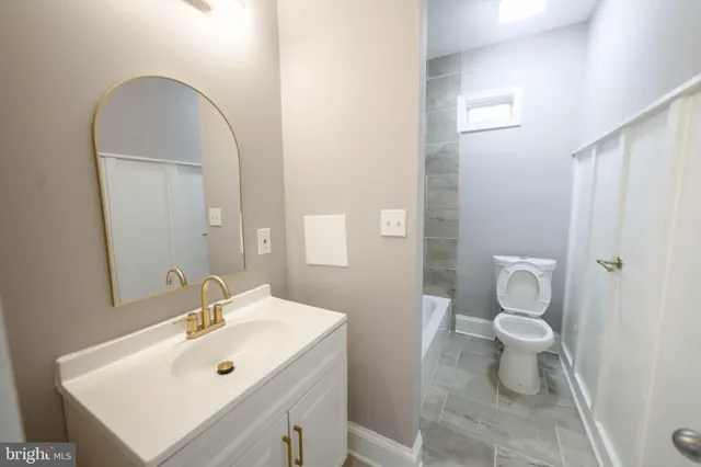 a bathroom with a sink toilet and a mirror