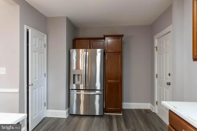 a view of a kitchen with wooden floor and electronic appliances
