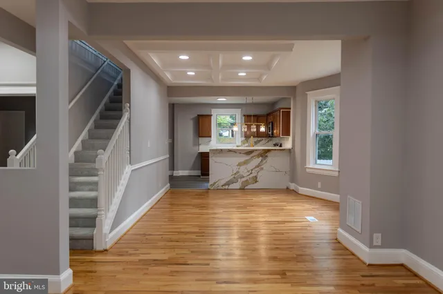 a view of a living room with wooden floor and staircase