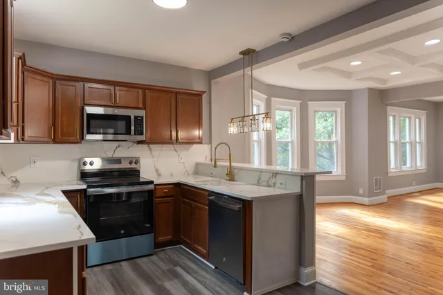 a kitchen with stainless steel appliances granite countertop a sink stove and microwave