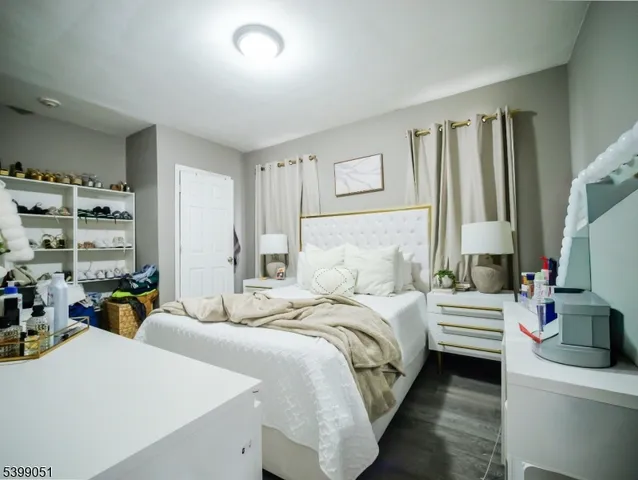 a bedroom with a bed dresser and a flat tv screen