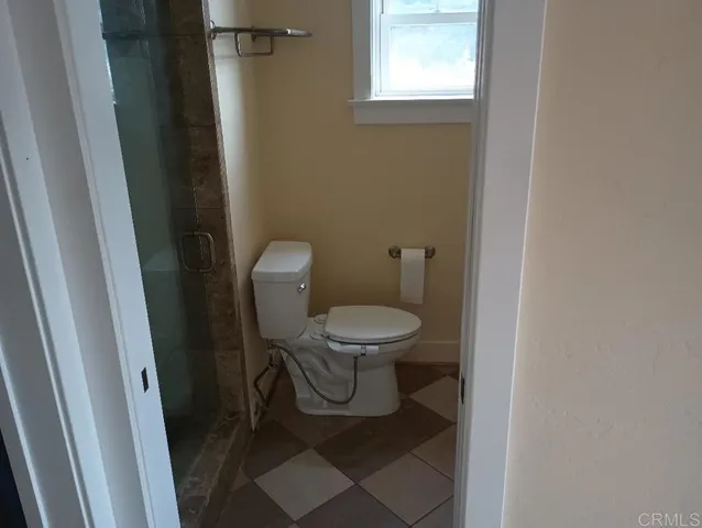 a white toilet sitting next to a window