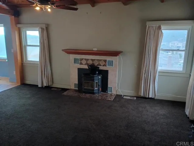 an empty room with windows dryer and a fireplace