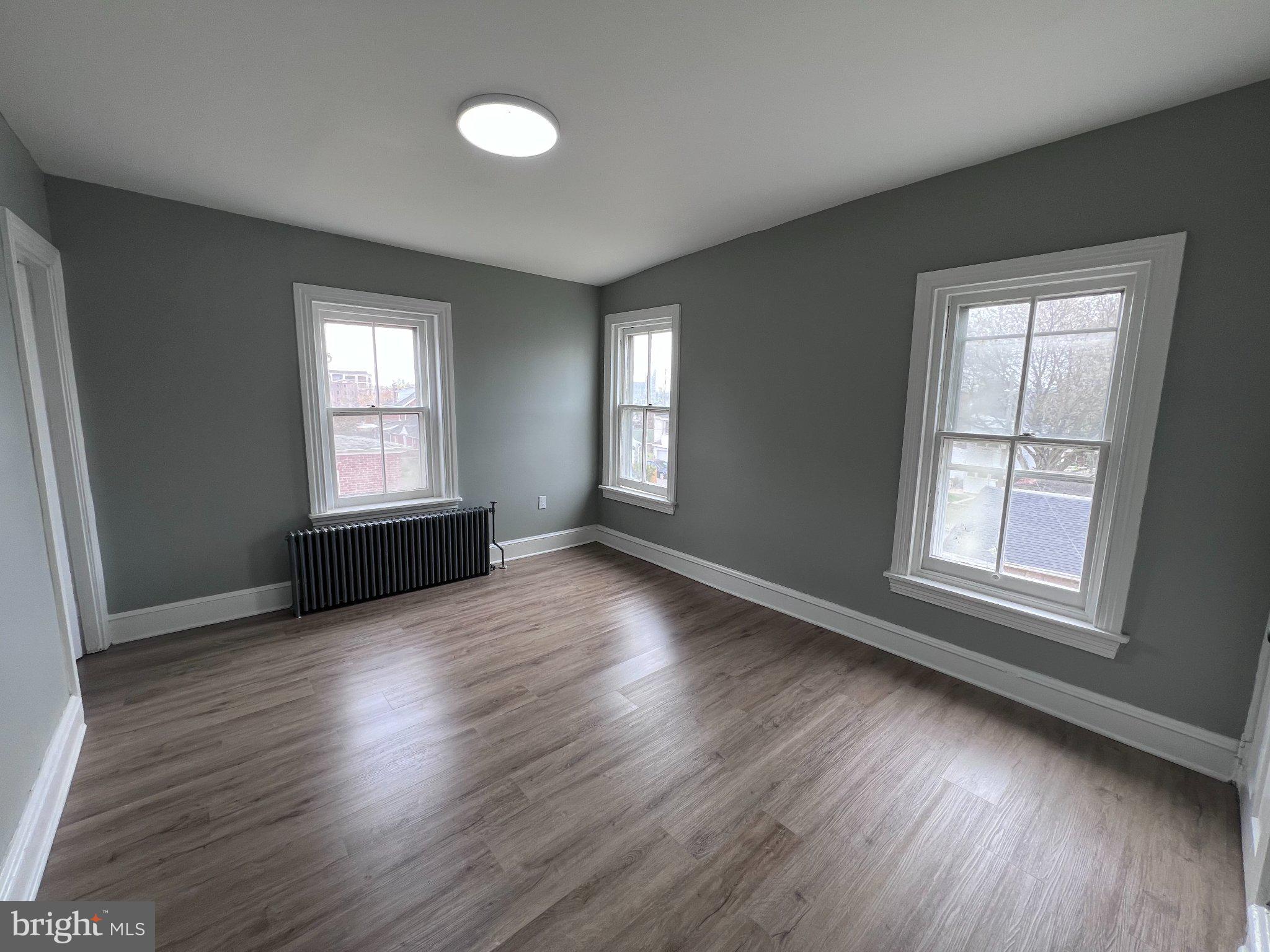 26 East 5th Street Pottstown, PA 19464 - Photo 19 of 37 an empty room with wooden floor and windows