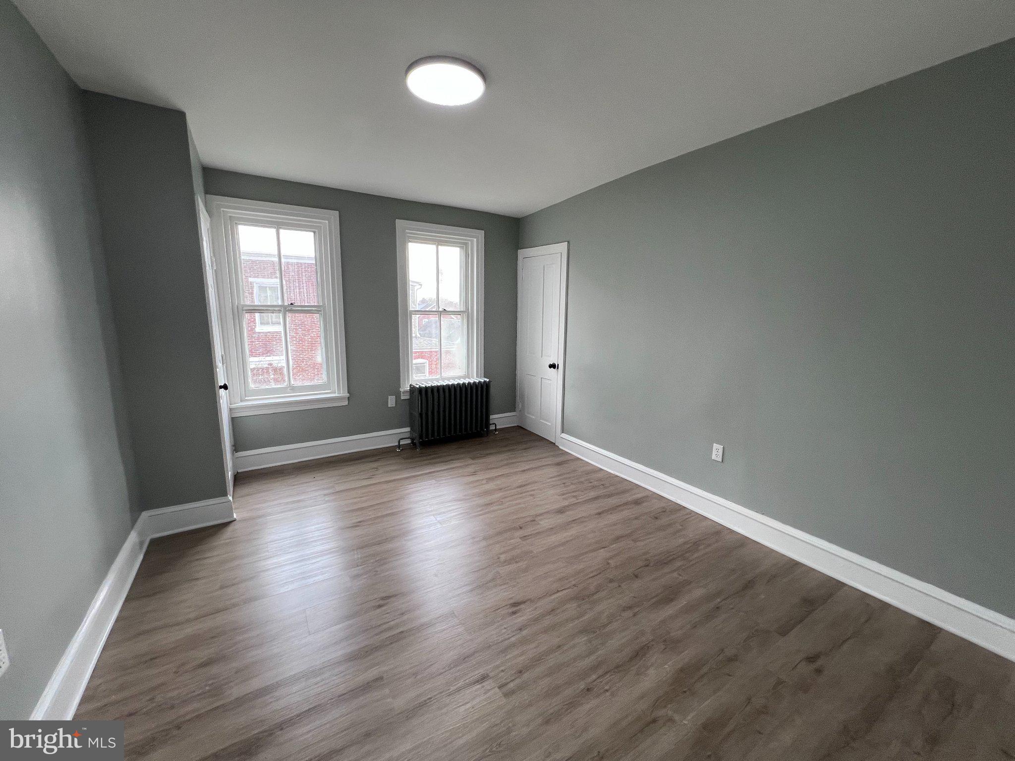26 East 5th Street Pottstown, PA 19464 - Photo 25 of 37 an empty room with wooden floor and windows