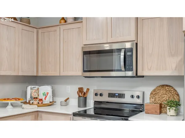 a kitchen with stainless steel appliances a stove a microwave and cabinets