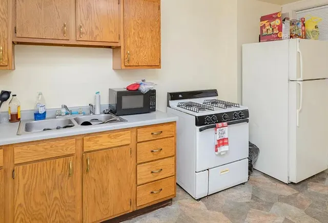 a kitchen with granite countertop cabinets and white appliances