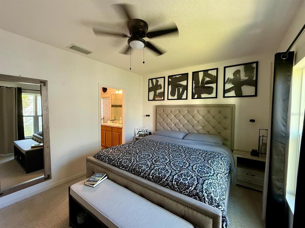 813 Marcel Loop Davenport, FL 33837 - Photo 16 of 34 a bedroom with a large bed and a chandelier