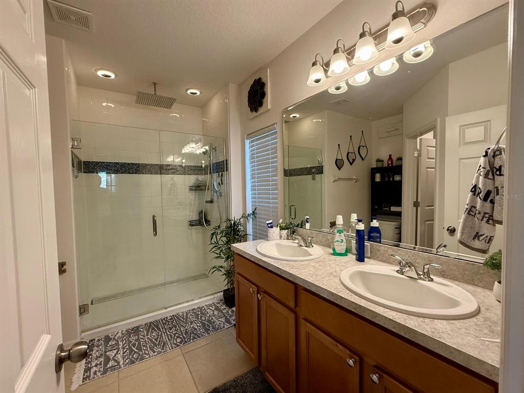 813 Marcel Loop Davenport, FL 33837 - Photo 19 of 34 a spacious bathroom with a double vanity sink mirror and shower