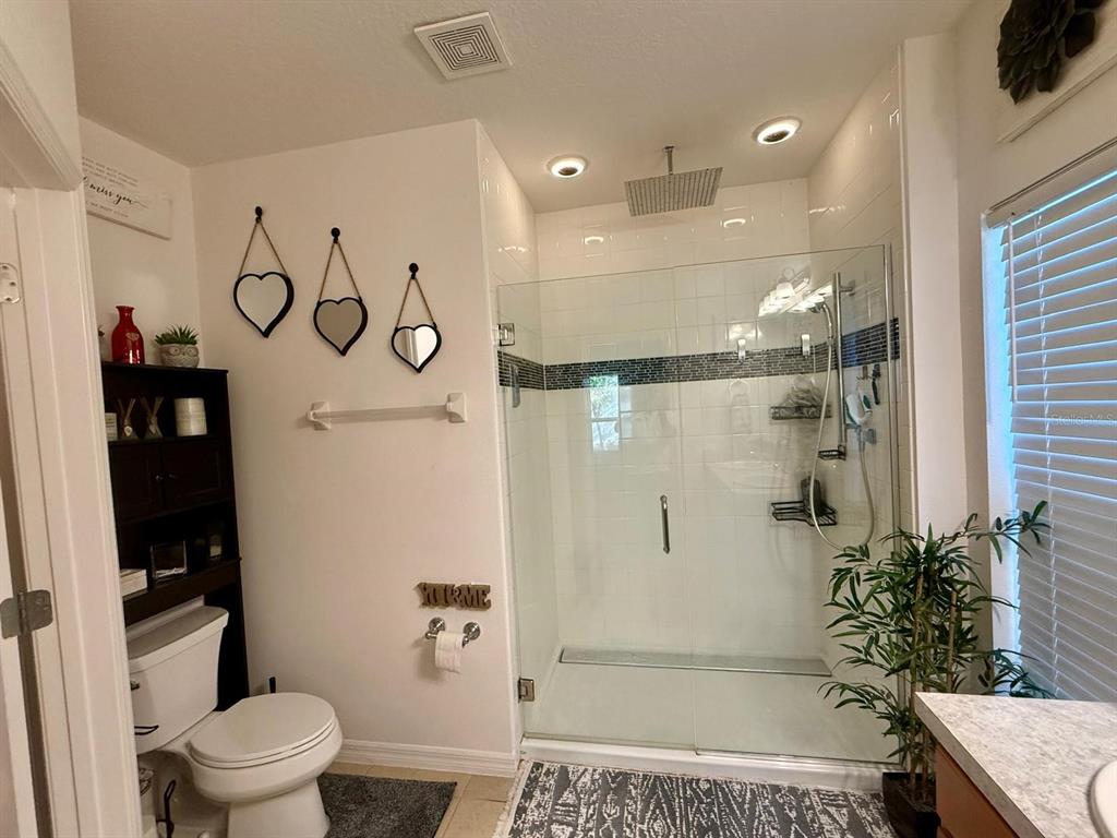 813 Marcel Loop Davenport, FL 33837 - Photo 20 of 34 a bathroom with a shower and a toilet