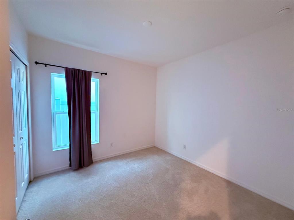 813 Marcel Loop Davenport, FL 33837 - Photo 24 of 34 an empty room with closet and windows