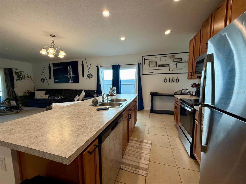 813 Marcel Loop Davenport, FL 33837 - Photo 7 of 34 a kitchen with stainless steel appliances granite countertop a refrigerator a stove and a sink