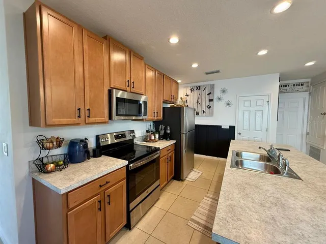 a kitchen with a dining table chairs and refrigerator