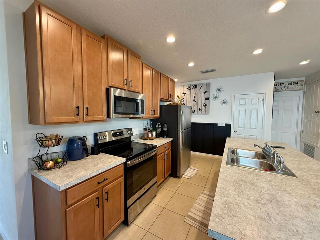 813 Marcel Loop Davenport, FL 33837 - Photo 8 of 34 a kitchen with granite countertop a sink stainless steel appliances and cabinets