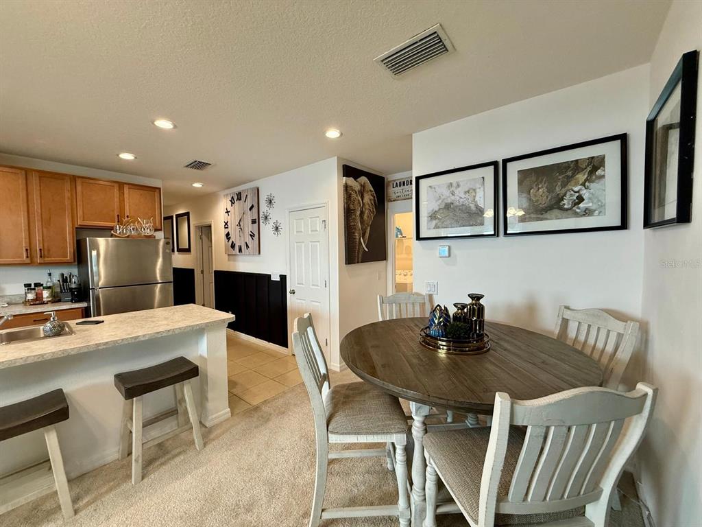 813 Marcel Loop Davenport, FL 33837 - Photo 9 of 34 a kitchen with a dining table chairs and refrigerator