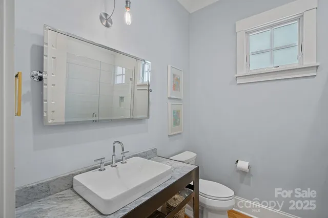 a bathroom with a sink toilet and mirror
