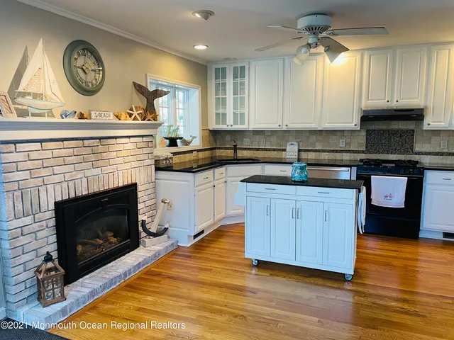 a kitchen with a stove cabinets and wooden floor