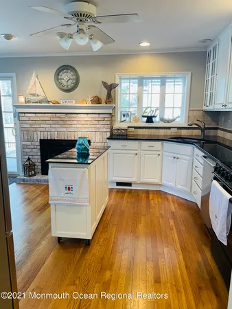 a view of a kitchen with a stove wooden floor and a clock