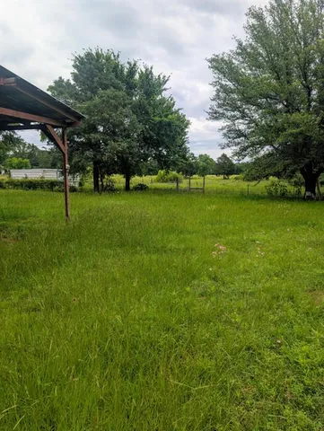 a view of a field of grass and trees
