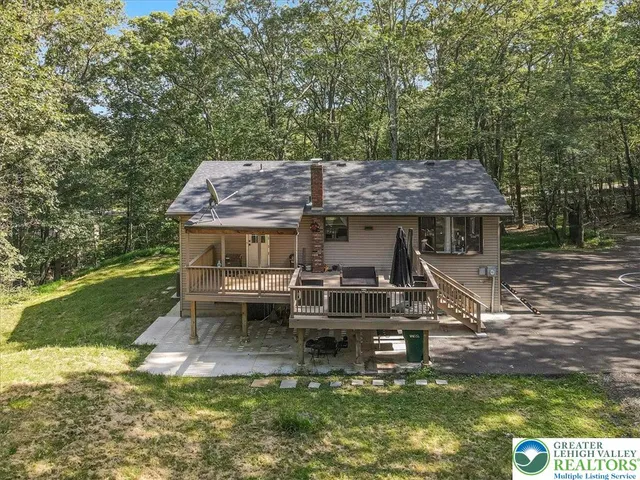 a view of a house with backyard and trees