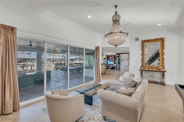 a living room with furniture a chandelier and a large window