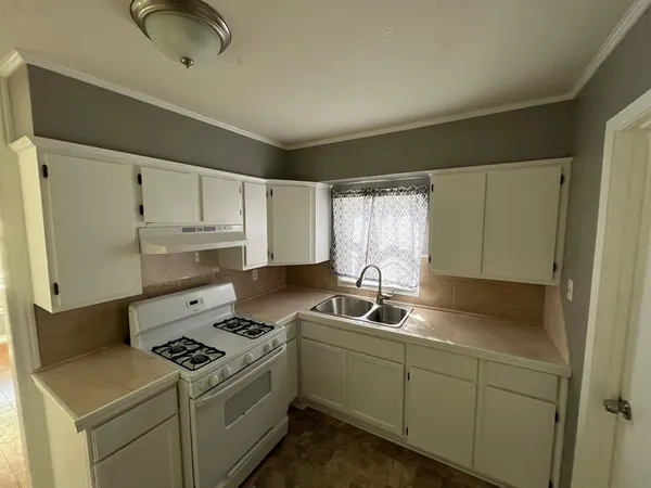 a kitchen with a sink stove and cabinets