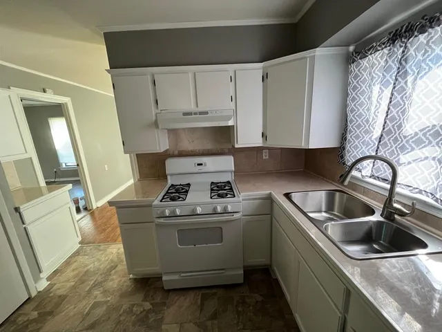 a kitchen with a sink stove and cabinets