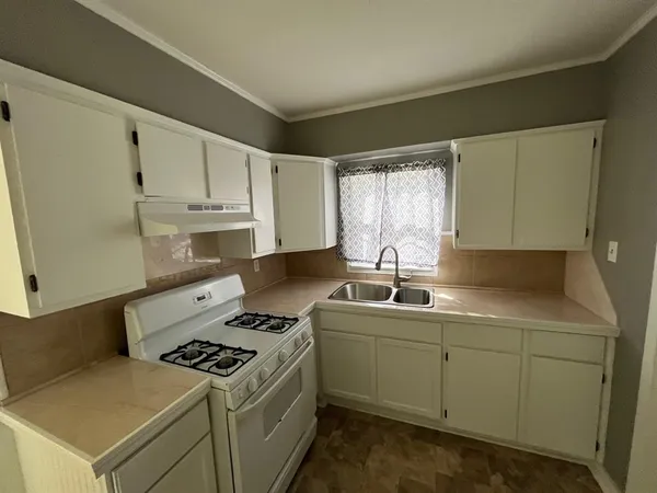 a kitchen with a sink a stove and cabinets