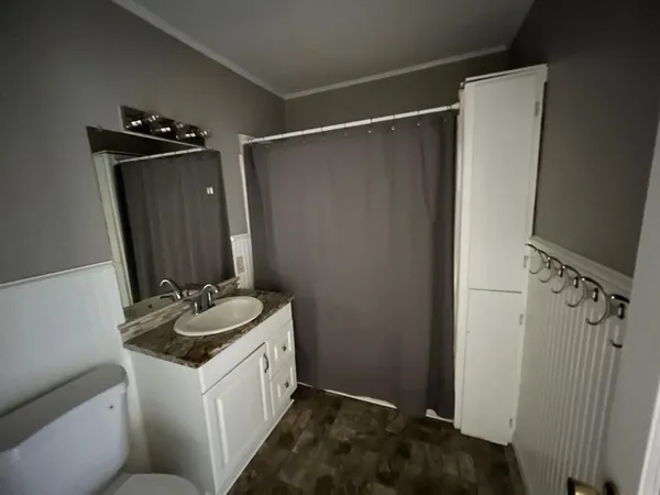 a bathroom with a sink and mirror with toilet