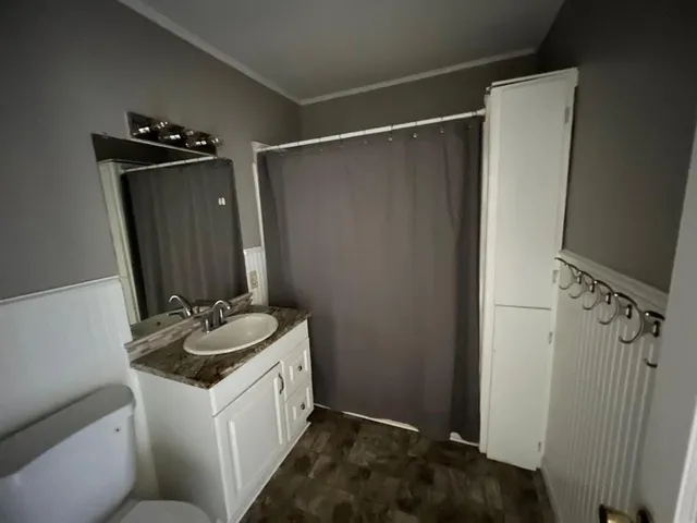 a bathroom with a sink and mirror with toilet