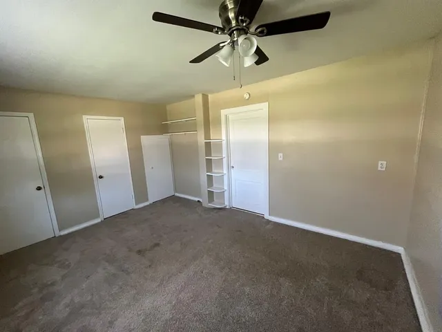 an empty room with a fan and a fan