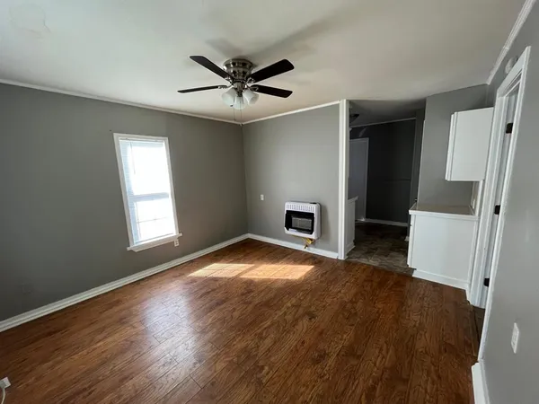 a view of empty room with wooden floor and fireplace