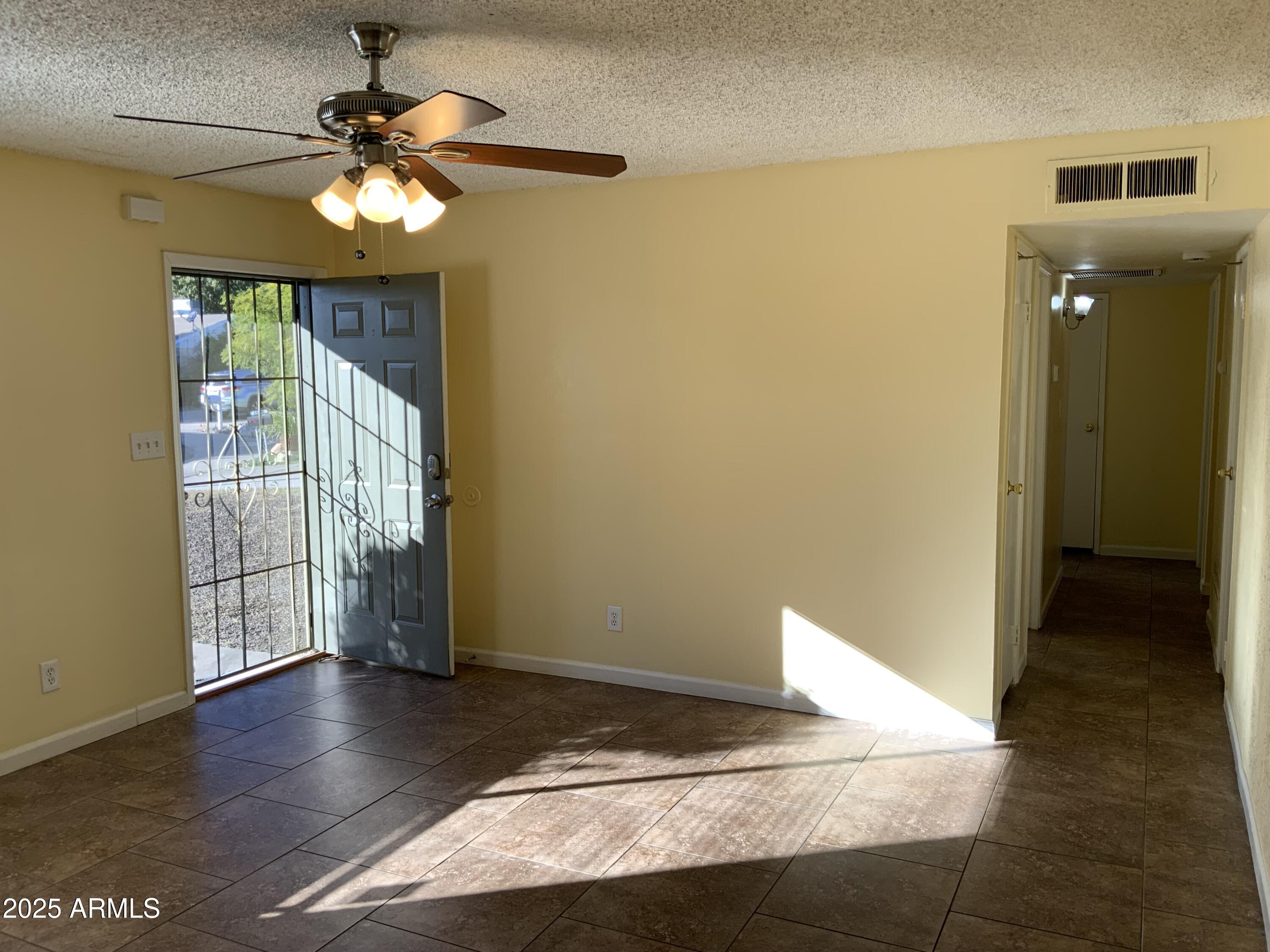 15831 North 59th Circle Glendale, AZ 85306 - Photo 2 of 12 a view of a livingroom with a hardwood floor and a ceiling fan