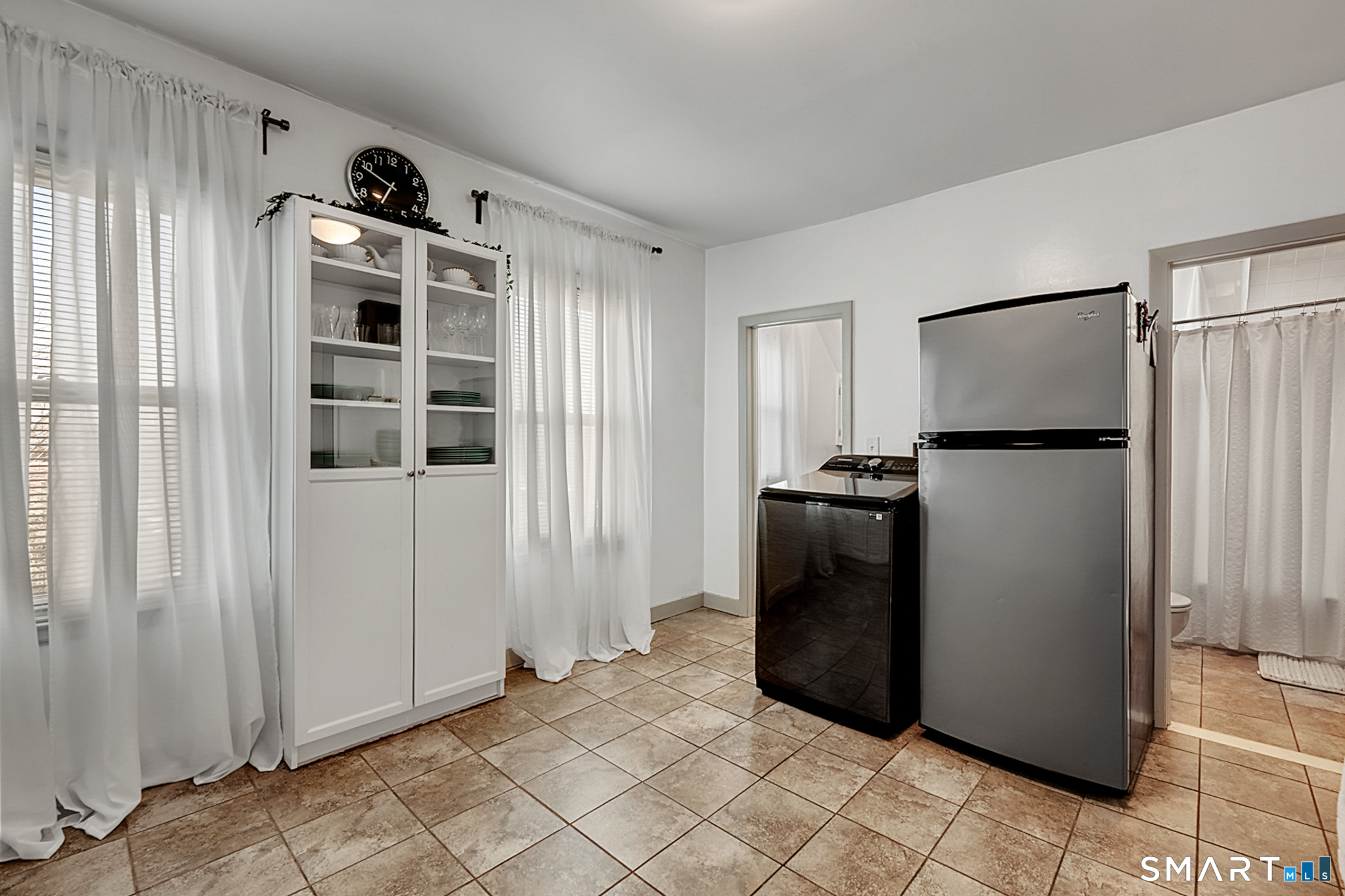 112 Austin Street New Britain, CT 06051 - Photo 13 of 40 a view of a refrigerator and an empty room with wooden floor windows