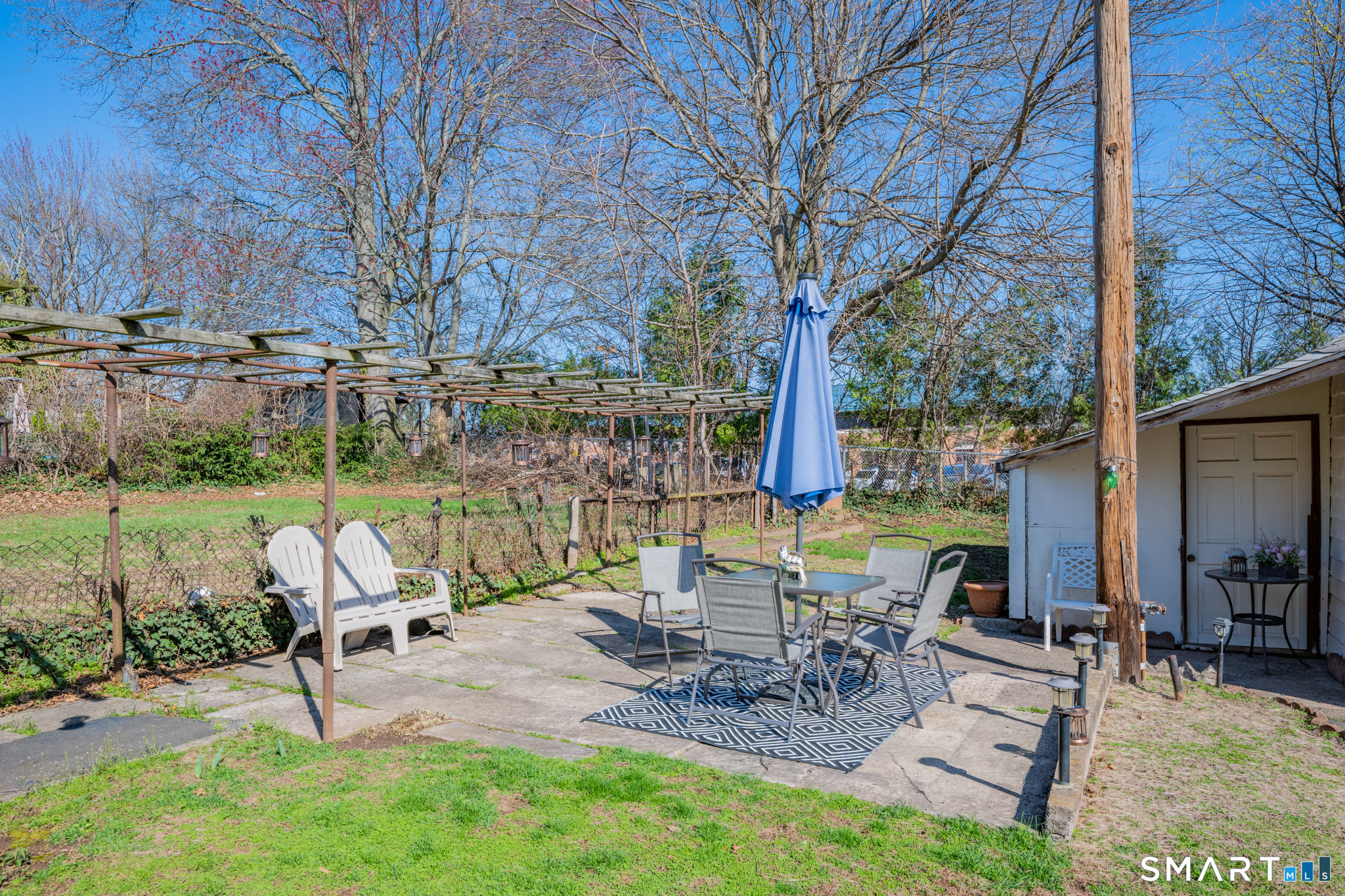 112 Austin Street New Britain, CT 06051 - Photo 31 of 40 a view of a patio with table and chairs potted plants and large tree