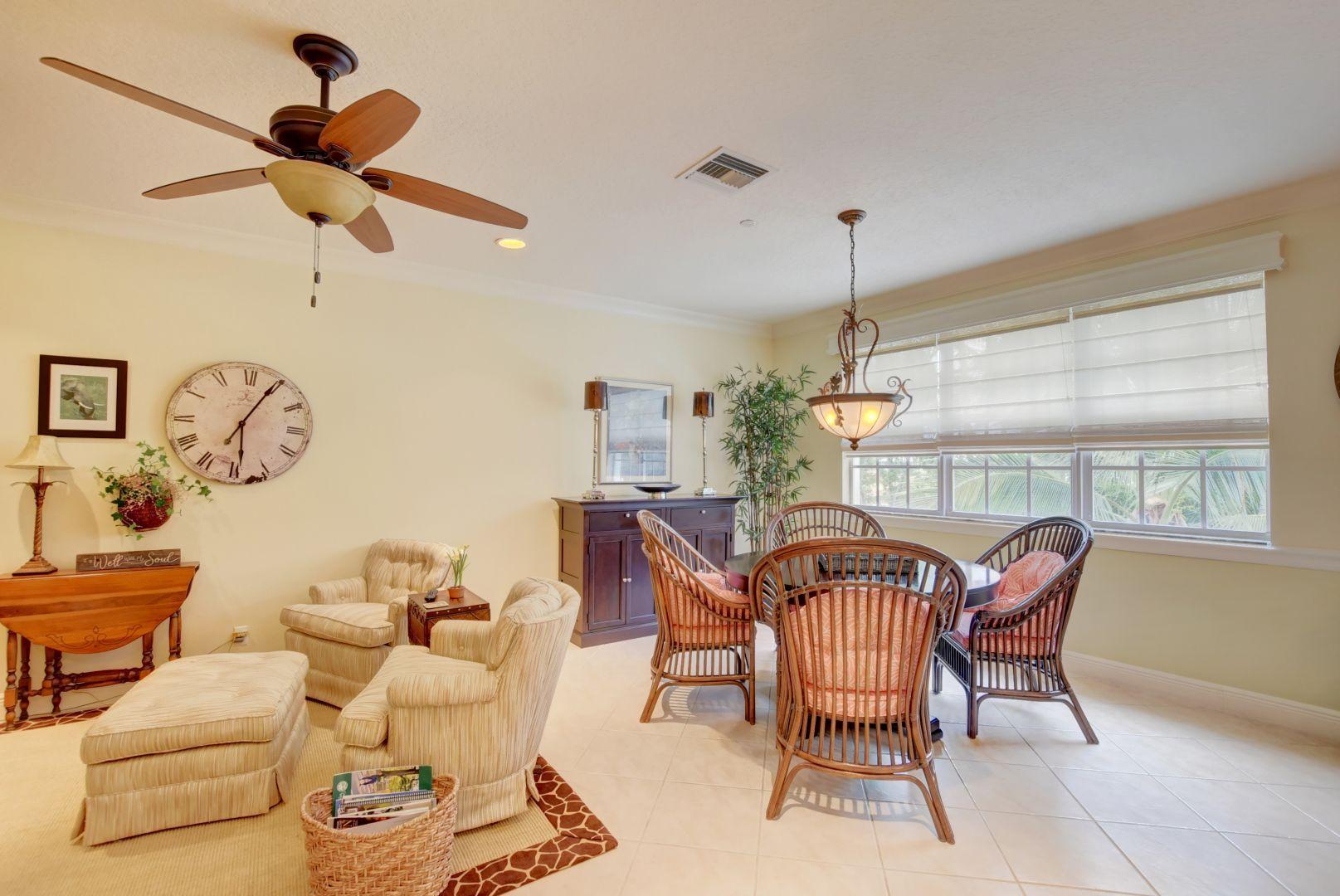5530 Northeast Trieste Way Boca Raton, FL 33487 - Photo 15 of 56 a dining room with furniture a chandelier and wooden floor