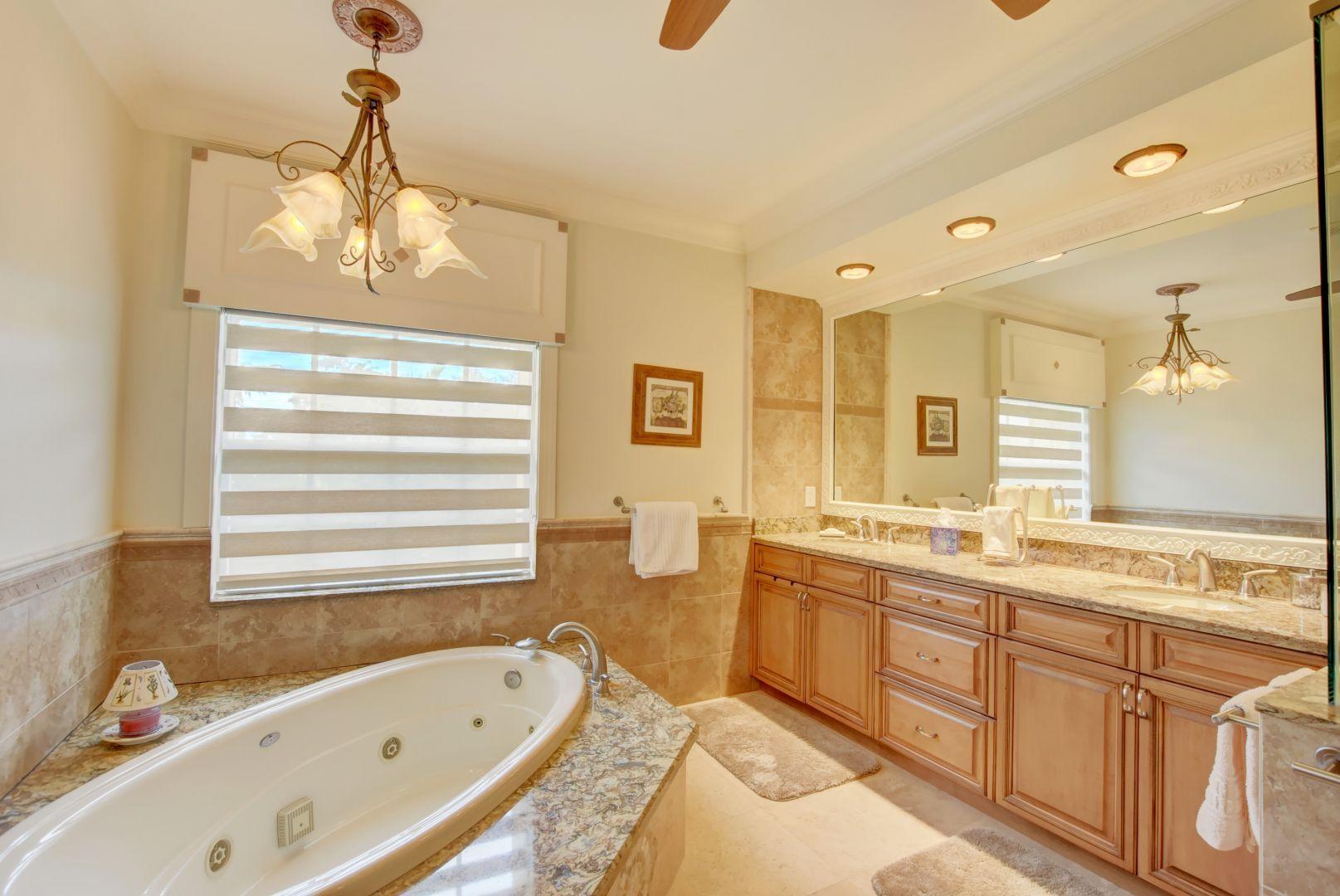 5530 Northeast Trieste Way Boca Raton, FL 33487 - Photo 21 of 56 a bathroom with a tub sink and mirror