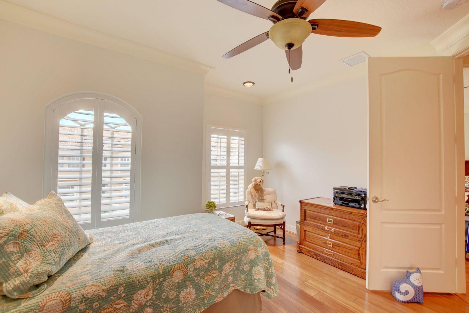 5530 Northeast Trieste Way Boca Raton, FL 33487 - Photo 23 of 56 a bedroom with a bed and wooden floor