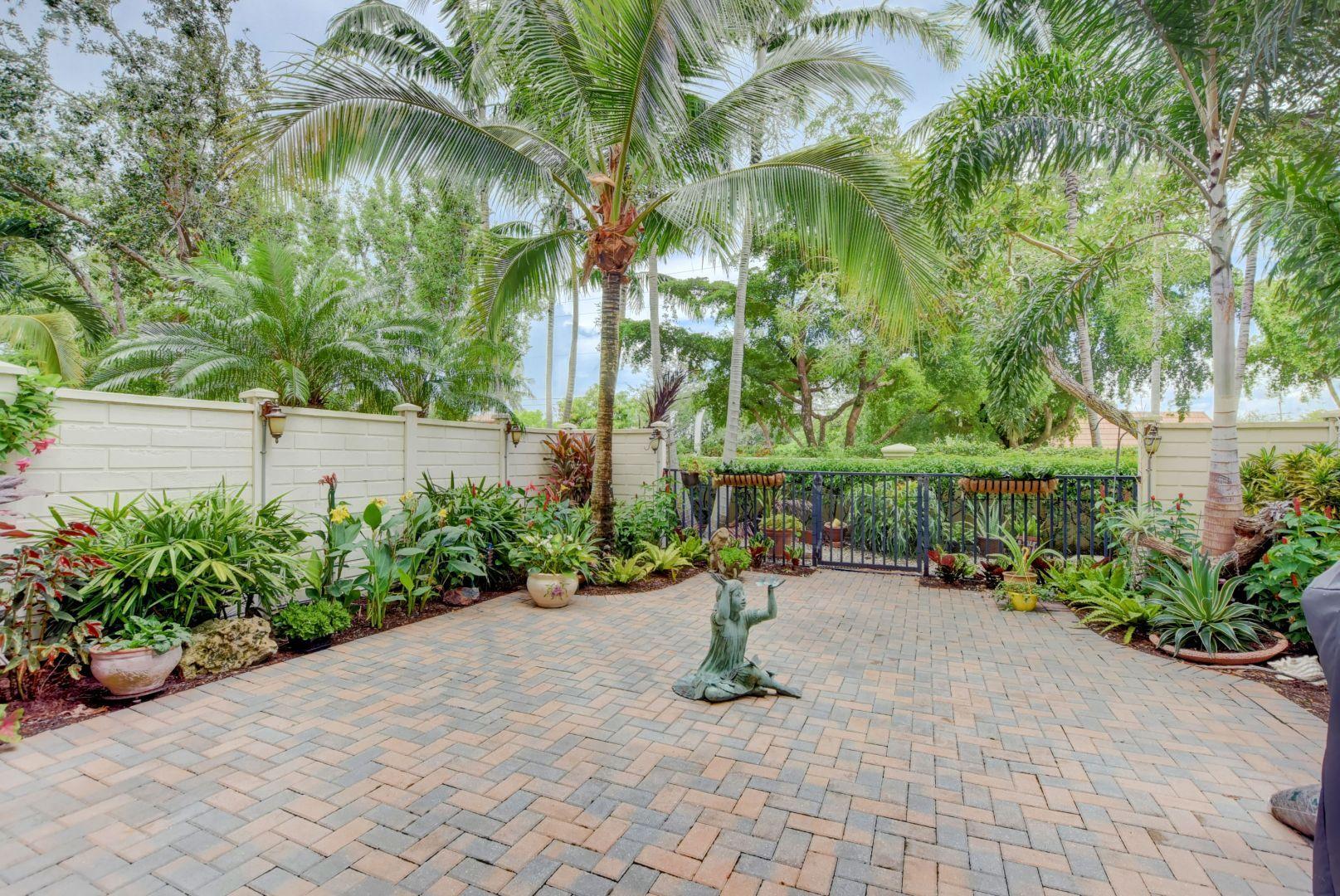 5530 Northeast Trieste Way Boca Raton, FL 33487 - Photo 39 of 56 a bench is sitting in the middle of a yard