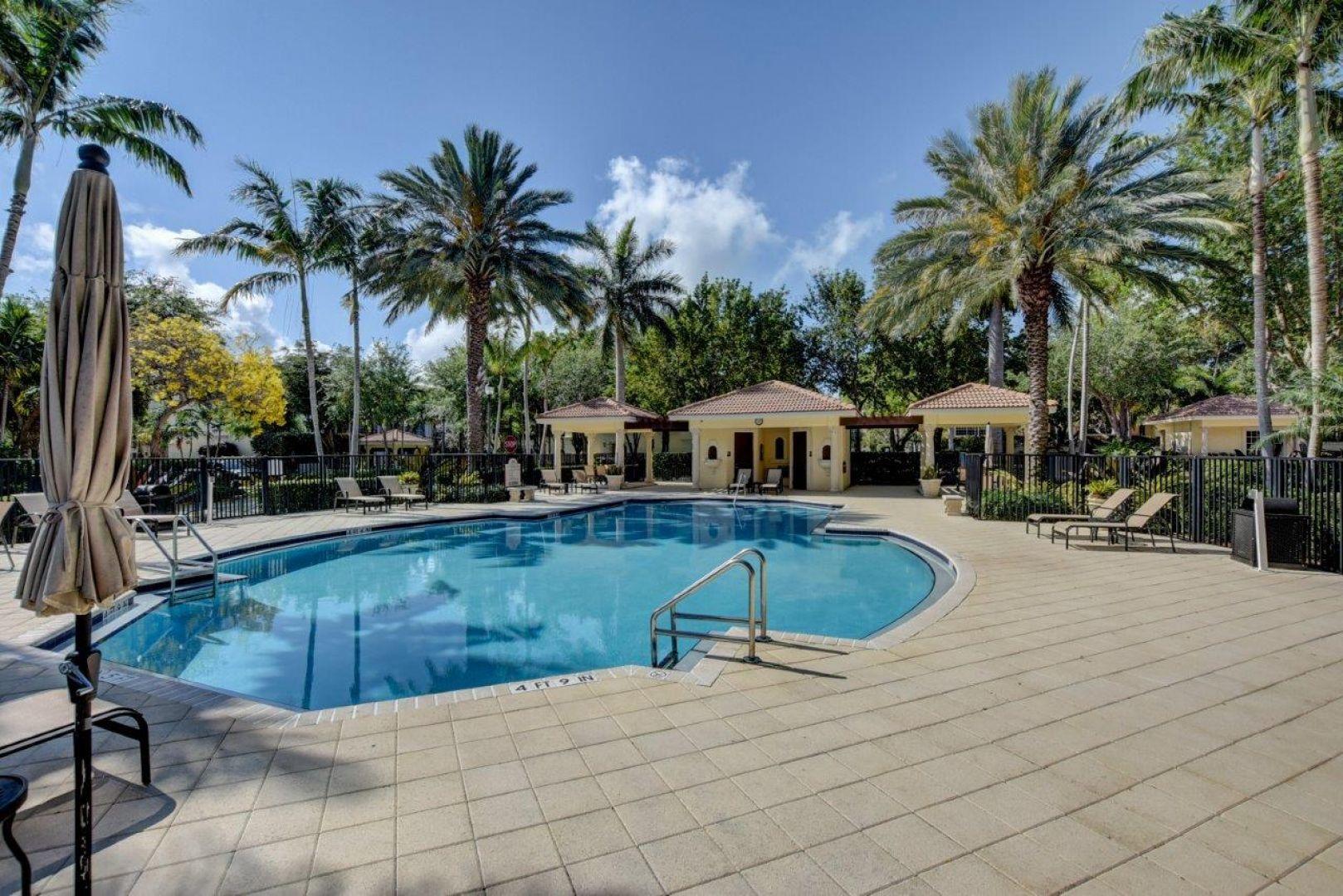 5530 Northeast Trieste Way Boca Raton, FL 33487 - Photo 41 of 56 a swimming pool with outdoor seating and yard
