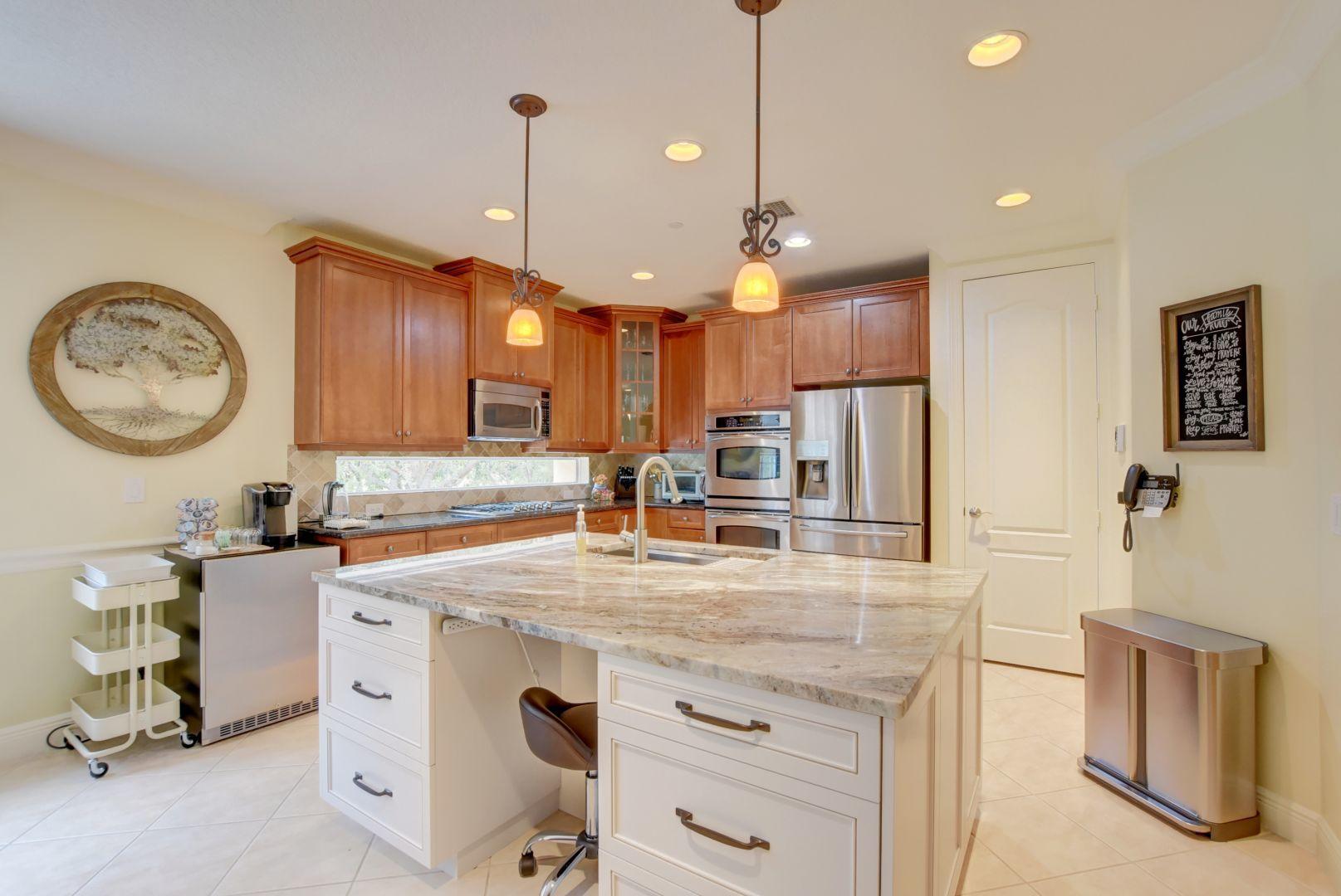 5530 Northeast Trieste Way Boca Raton, FL 33487 - Photo 5 of 56 a kitchen with stainless steel appliances granite countertop a sink a stove and a wooden floors