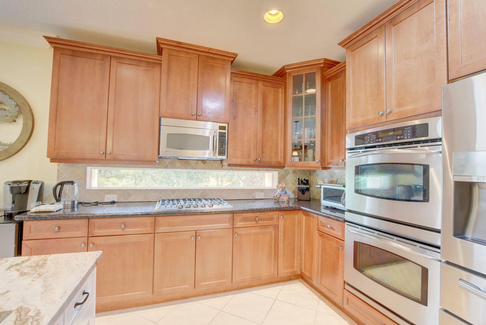 5530 Northeast Trieste Way Boca Raton, FL 33487 - Photo 6 of 56 a kitchen with stainless steel appliances granite countertop a sink and a microwave