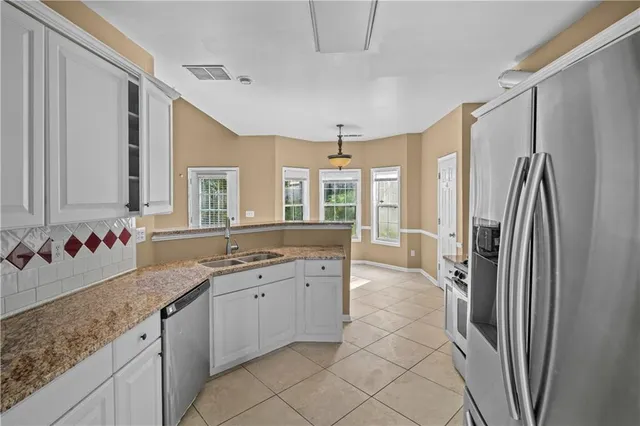 a large bathroom with a granite countertop double vanity sink a mirror and a shower