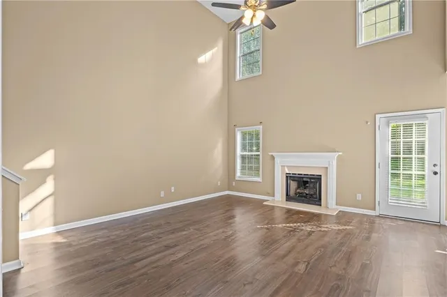 a view of empty room with wooden floor and fireplace